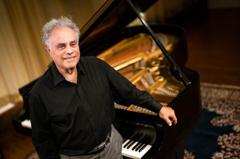 man standing next to piano