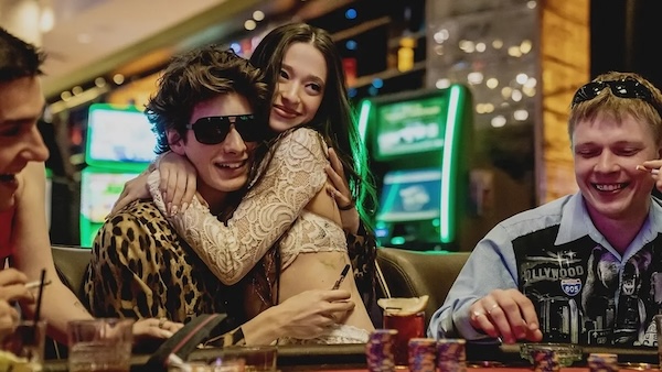 woman sitting on a man's lap hugging him at a gambling table