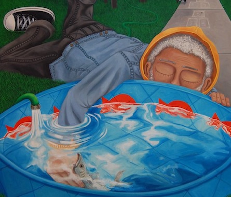 grey haired person laying in grass with arm in kids pool, orange fish swim inside.