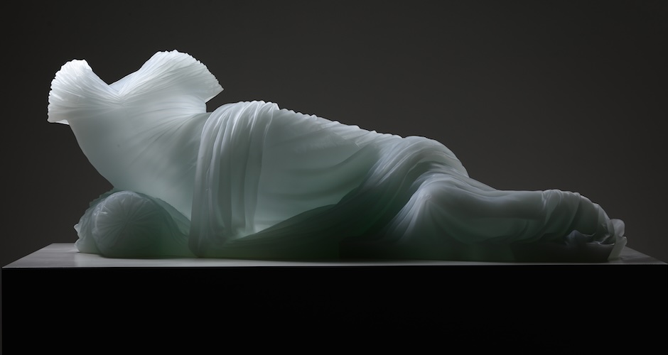 Form of woman laying, just glass dress providing form