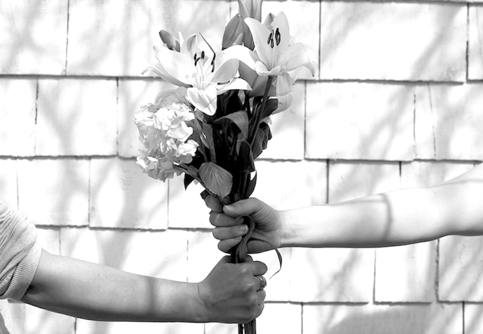 close up two people holding same bunch of flowers black and white image still from video